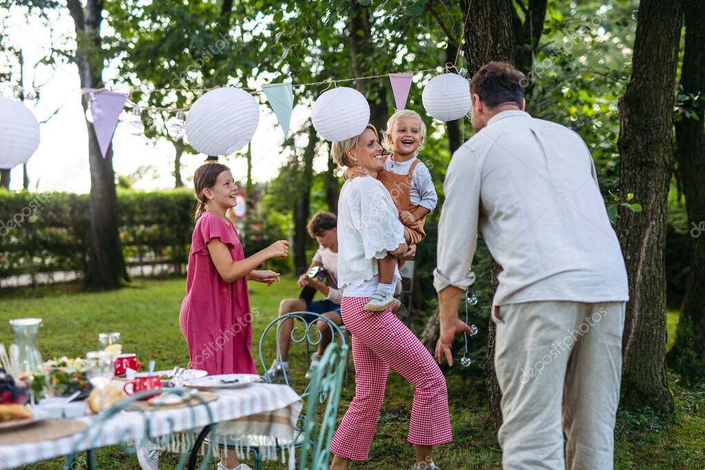 Stimmungsvolle Lichterkette über Tischen beim Gartenfest